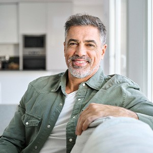 Man smiling while relaxing on couch at home