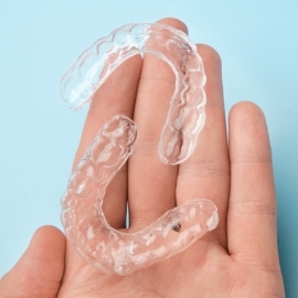 Hand holding two clear aligners
