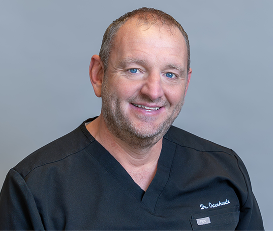 West Jordan dentist Doctor O smiling in black scrubs