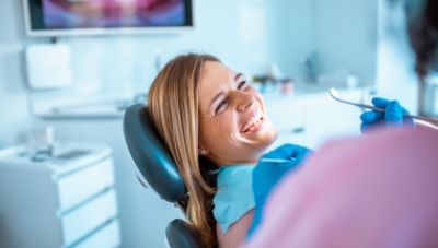 Woman in dental chair grinning at her dentist