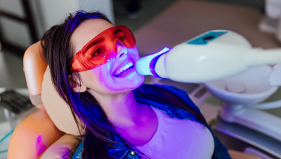 Woman in dental chair grinning at her dentist