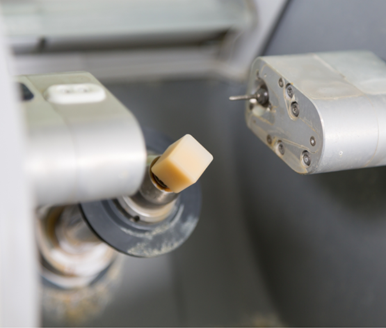 Small ceramic cube in a machine for creating same day dental crowns