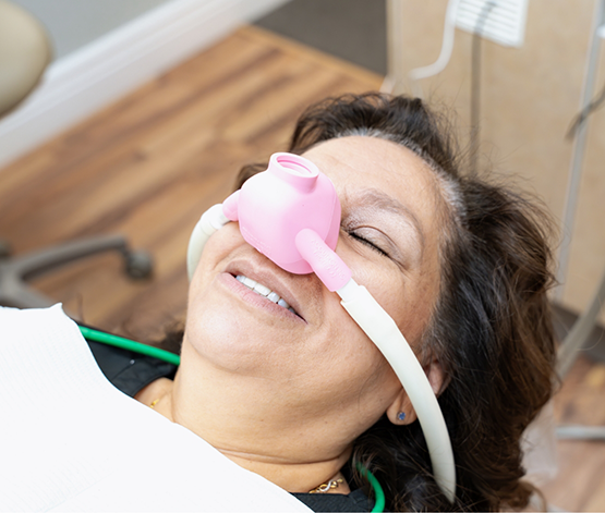 Dental patient relaxing with a nitrous oxide mask over her nose