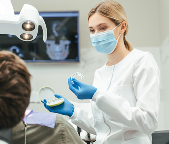Dentist showing patient clear aligner in treatment room