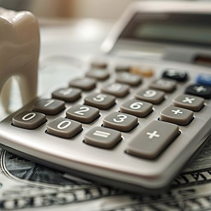 Tooth and calculator on a stack of money
