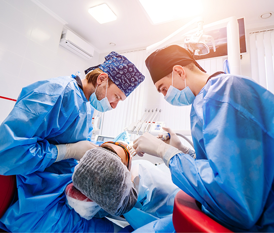 Two dental professionals performing wisdom tooth extractions in West Jordan on a patient