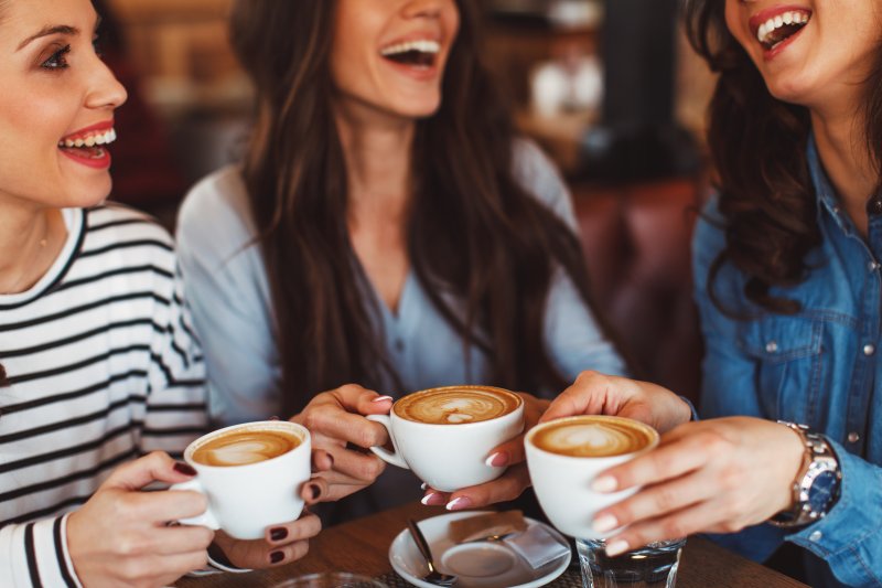 Patient smiling with friends enjoying coffee with SureSmile