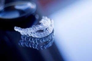 Pair of clear aligners on dark reflective surface